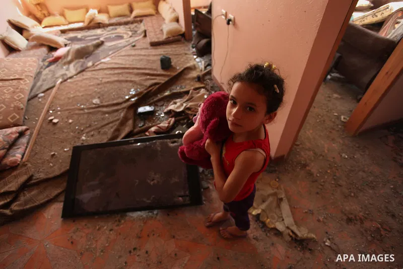 A Palestinian girl carries her doll inside her family house after it was hit by Israeli tank fire on September 6, 2016 in Beit Hanun in the northern Gaza Strip. Israel's army targeted Hamas posts in the Gaza Strip with t...