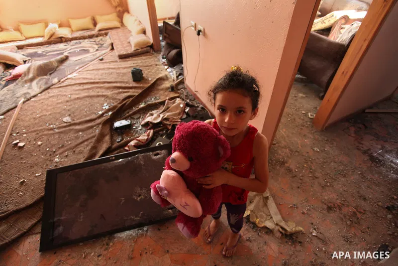 A Palestinian girl carries her doll inside her family house after it was hit by Israeli tank fire on September 6, 2016 in Beit Hanun in the northern Gaza Strip. Israel's army targeted Hamas posts in the Gaza Strip with t...