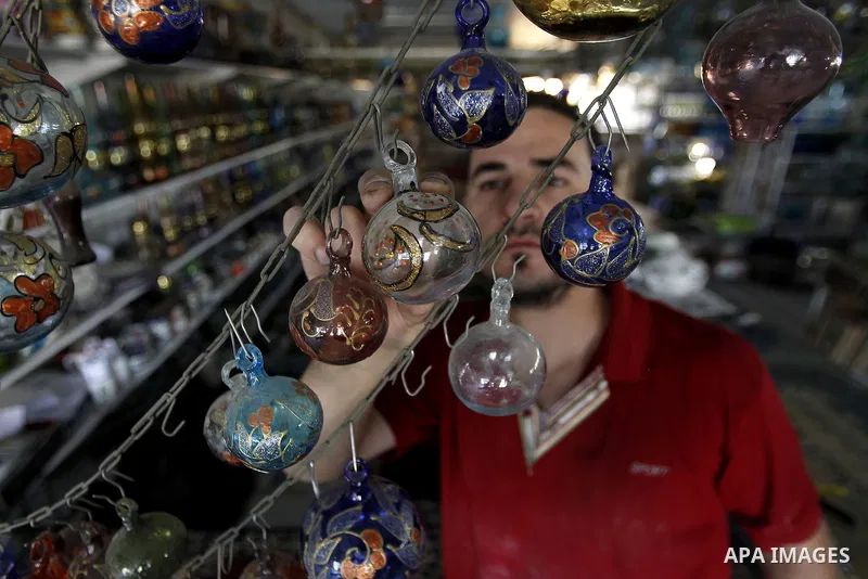 A Palestinian man uses types of glasses to decorate his factory in the West Bank city of Hebron, on Sep. 07, 2016. Hebron, the largest city in the West Bank has been officially awarded the title of World Crafts City, Rol...
