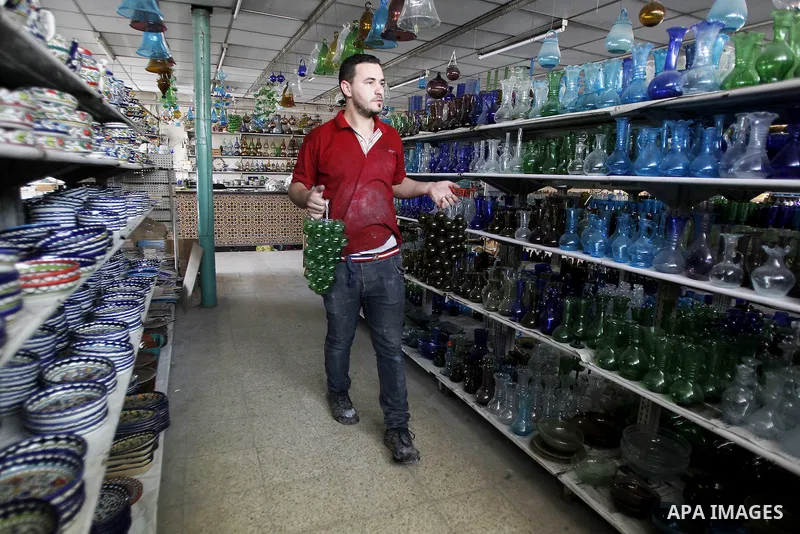 A Palestinian man uses types of glasses to decorate his factory in the West Bank city of Hebron, on Sep. 07, 2016. Hebron, the largest city in the West Bank has been officially awarded the title of World Crafts City, Rol...