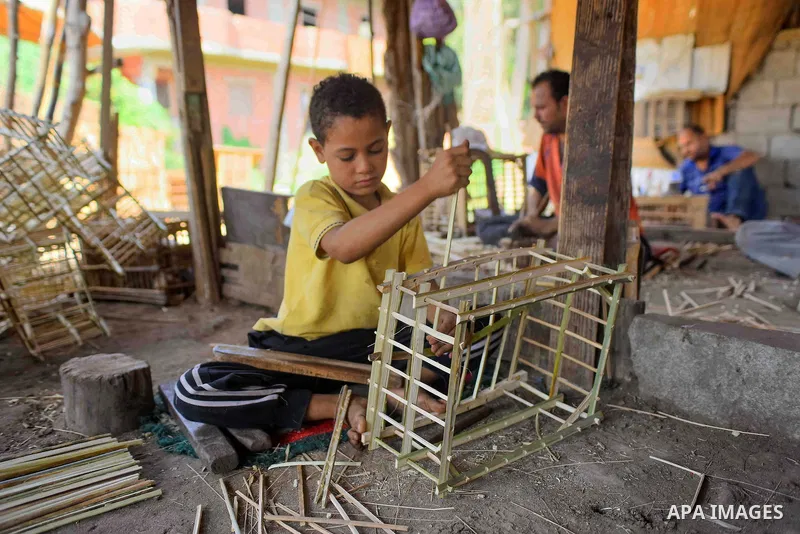 An Egyptian boy weaves straw-traditional products, at their workshop, in Cairo, Egypt, on September 7, 2016. Photo by Amr Sayed