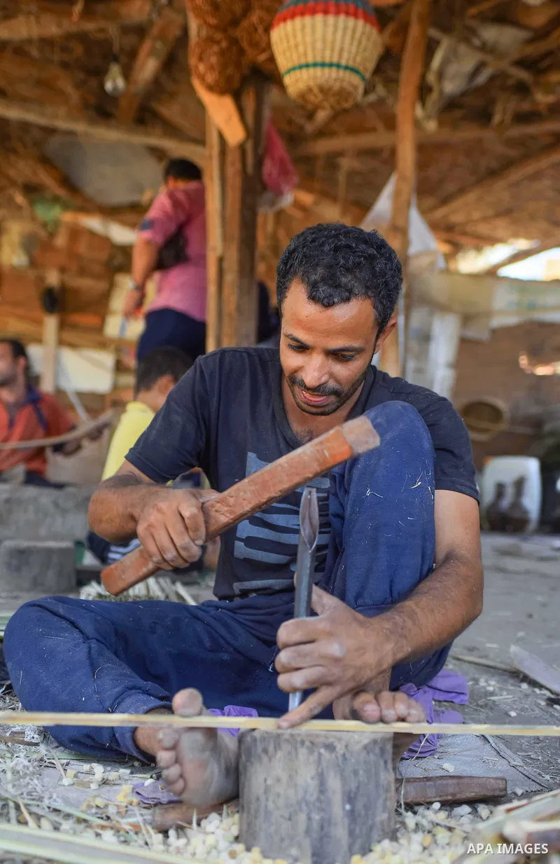 An Egyptian man weaves straw-traditional products, at their workshop, in Cairo, Egypt, on September 7, 2016. Photo by Amr Sayed