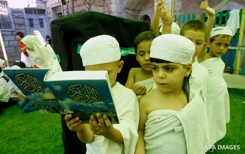 Palestinian children gather around a makeshift cube representing the holy Kaaba, in the West bank city of Hebnron, on Sept. 8, 2016, as part of training children how to perform Hajj pilgrimage. Muslims from around the wo...