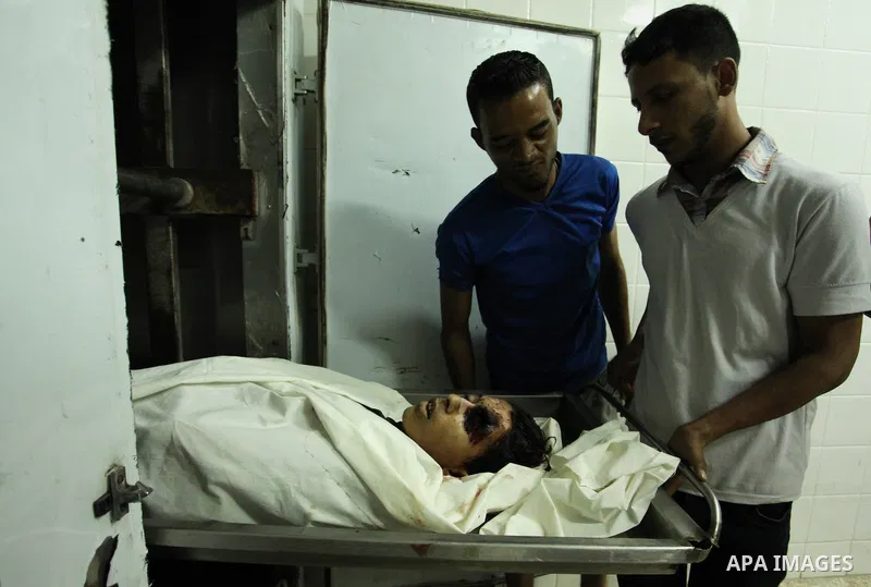 People gather around the body of Palestinian youth Abdulrahman Al-Dabag, who medics said was shot dead by Israeli troops on Friday, at a hospital morgue in the central Gaza Strip September 9, 2016. Photo by Ashraf Amra