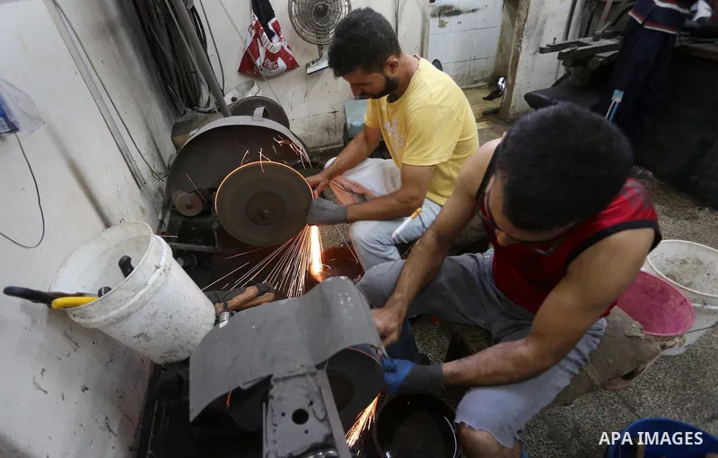 Palestinian men sharpen knives at his workshop in Gaza city on Sept. 10, 2016. The knives use to slaughter cattle and sheep for the Muslim holiday of Eid al-Adha or the Feast of Sacrifice, which marks the end of the annu...