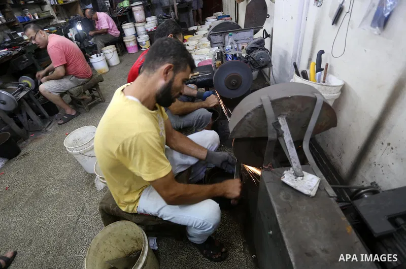 Palestinian men sharpen knives at his workshop in Gaza city on Sept. 10, 2016. The knives use to slaughter cattle and sheep for the Muslim holiday of Eid al-Adha or the Feast of Sacrifice, which marks the end of the annu...