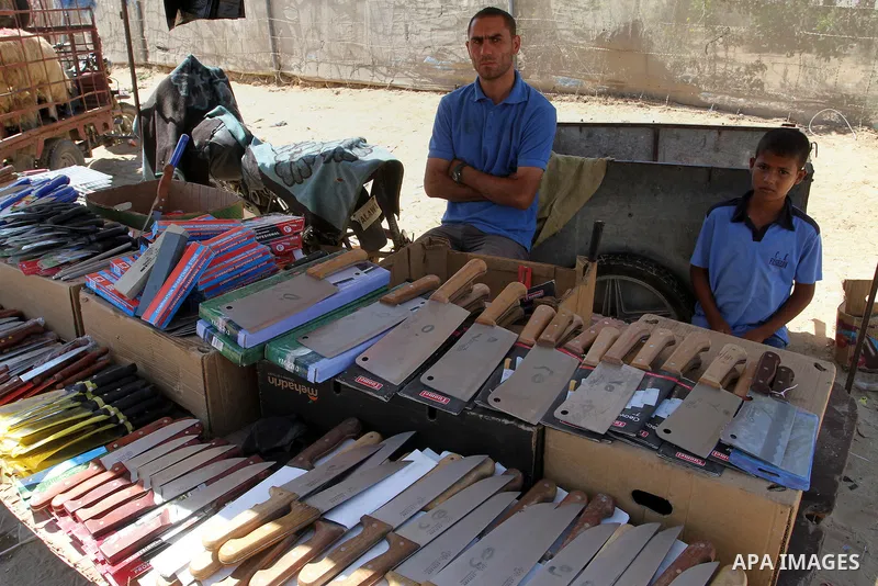 A Palestinian vendor displays knives at a market, ahead of the Eid al-Adha festival, in Rafah in the southern gaza strip September 10, 2016. The knives use to slaughter cattle and sheep for the Muslim holiday of Eid al-A...