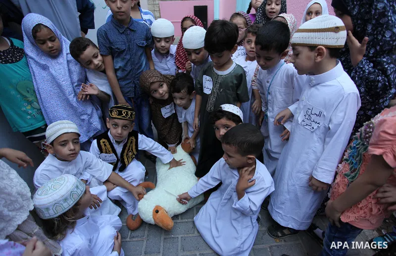 Palestinian children gather around a makeshift cube representing the holy Kaaba, in Gaza, on Sept. 10, 2016, as part of training children how to perform Hajj pilgrimage. Muslims from around the world flood Saudi city of...