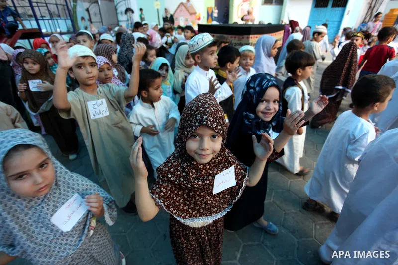 Palestinian children gather around a makeshift cube representing the holy Kaaba, in Gaza, on Sept. 10, 2016, as part of training children how to perform Hajj pilgrimage. Muslims from around the world flood Saudi city of...