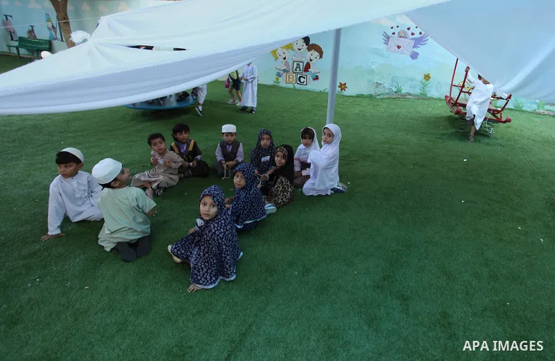 Palestinian children gather around a makeshift cube representing the holy Kaaba, in Gaza, on Sept. 10, 2016, as part of training children how to perform Hajj pilgrimage. Muslims from around the world flood Saudi city of...