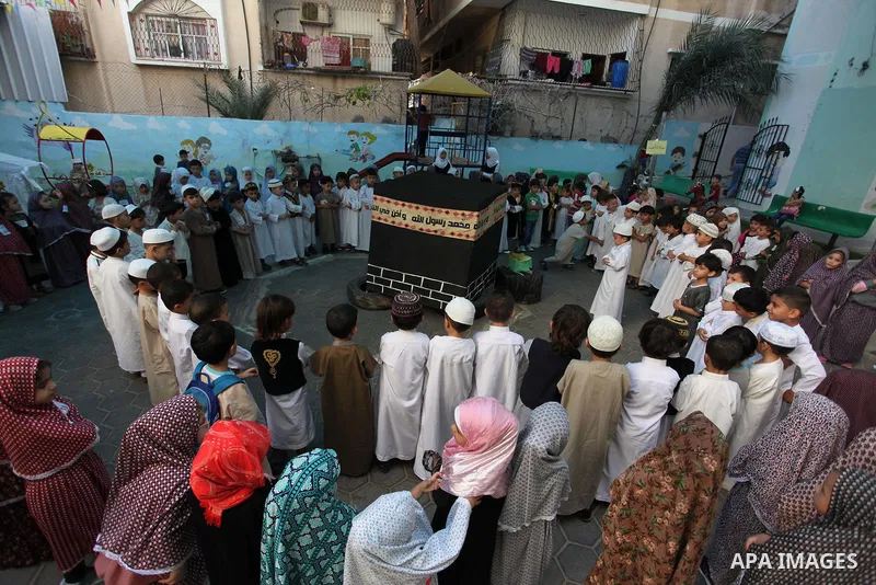 Palestinian children gather around a makeshift cube representing the holy Kaaba, in Gaza, on Sept. 10, 2016, as part of training children how to perform Hajj pilgrimage. Muslims from around the world flood Saudi city of...