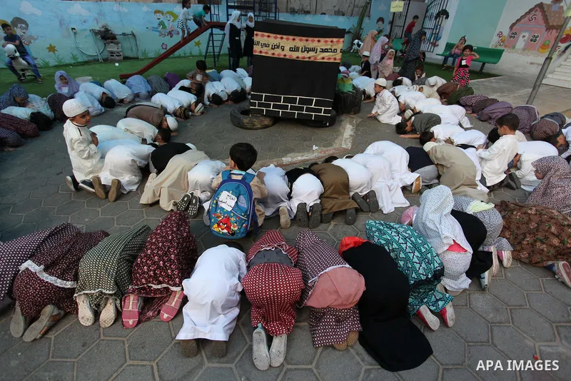 Palestinian children gather around a makeshift cube representing the holy Kaaba, in Gaza, on Sept. 10, 2016, as part of training children how to perform Hajj pilgrimage. Muslims from around the world flood Saudi city of...