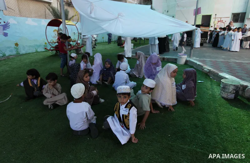 Palestinian children gather around a makeshift cube representing the holy Kaaba, in Gaza, on Sept. 10, 2016, as part of training children how to perform Hajj pilgrimage. Muslims from around the world flood Saudi city of...