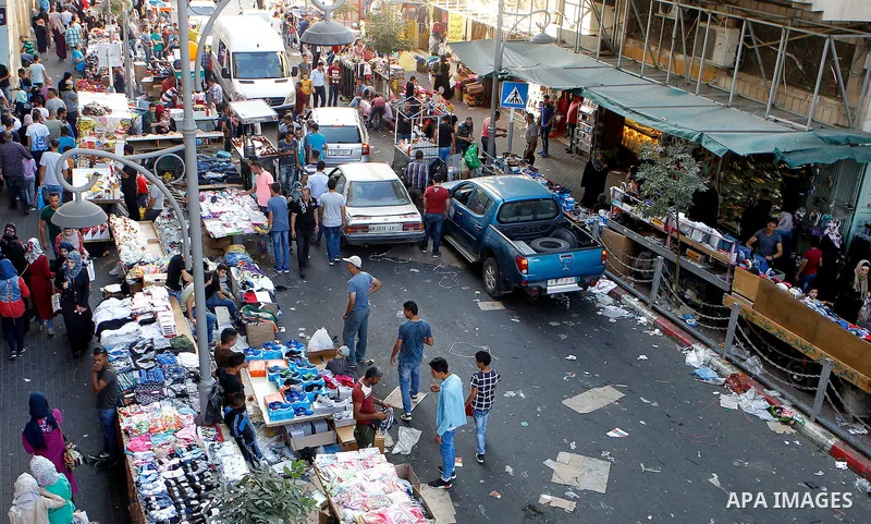 Palestinians shop at a market ahead of the Eid al-Adha festival in the West Bank town of Hebron on September 11, 2016. Photo by Wisam Hashlamoun