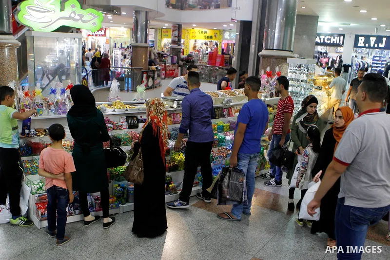 Palestinians shop at a market ahead of the Eid al-Adha festival in the West Bank town of Hebron on September 11, 2016. Photo by Wisam Hashlamoun