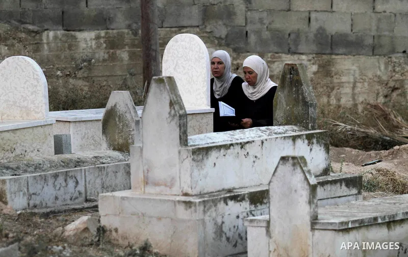 Palestinians visit the grave of their relative at a cemetery on the first day of of Eid al-Adha, or feast of the sacrifice, in the West Bank city of Nablus, on Sep. 12, 2016. Muslims around the world are celebrating Eid...