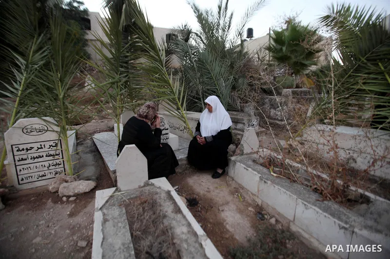 Palestinians visit the grave of their relative at a cemetery on the first day of of Eid al-Adha, or feast of the sacrifice, in the West Bank city of Nablus, on Sep. 12, 2016. Muslims around the world are celebrating Eid...