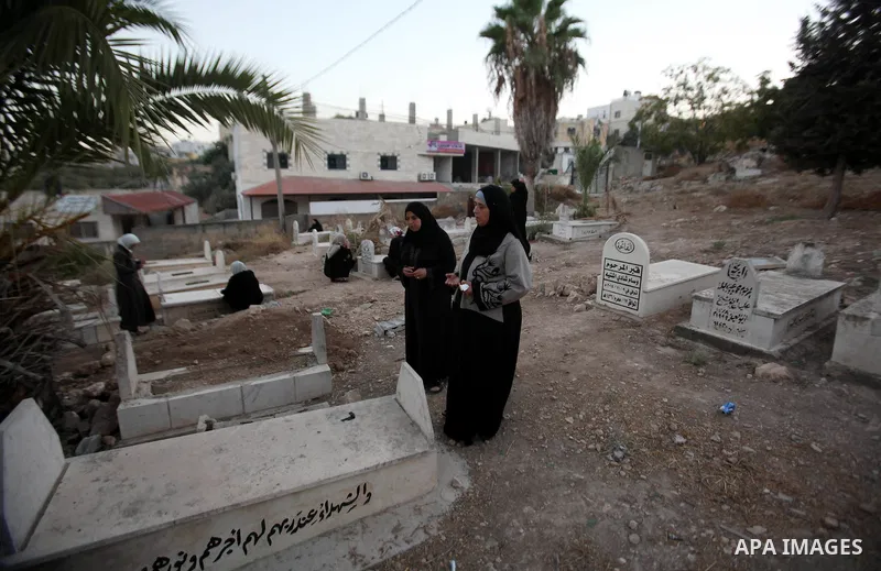 Palestinians visit the grave of their relative at a cemetery on the first day of of Eid al-Adha, or feast of the sacrifice, in the West Bank city of Nablus, on Sep. 12, 2016. Muslims around the world are celebrating Eid...