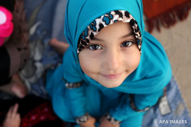 A Palestinian girl attends the morning prayer of the Muslim holiday of the Eid al-Adha on September 12, 2016, in Khan Younis in the southern Gaza strip. Muslims across the world celebrate the annual festival of Eid al-Ad...
