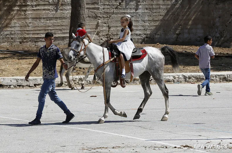 Palestinians enjoy the second day of Eid al-Adha or the feast of sacrifice, in the West Bank city of Hebron, on Sep. 13, 2016. Muslims across the world are celebrating the annual festival of Eid al-Adha, or the Festival...