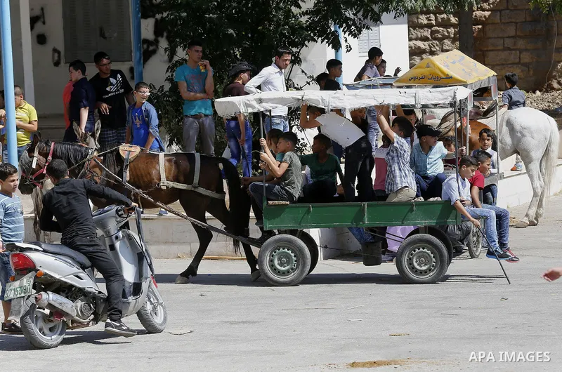 Palestinians enjoy the second day of Eid al-Adha or the feast of sacrifice, in the West Bank city of Hebron, on Sep. 13, 2016. Muslims across the world are celebrating the annual festival of Eid al-Adha, or the Festival...