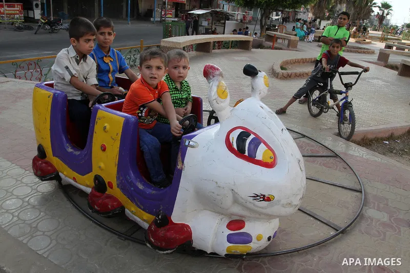 Palestinian children enjoy a ride at an amusement park during the second day of Eid al-Adha or the feast of sacrifice, in Rafah in the southern of Gaza strip, on Sep. 13, 2016. Muslims across the world are celebrating th...