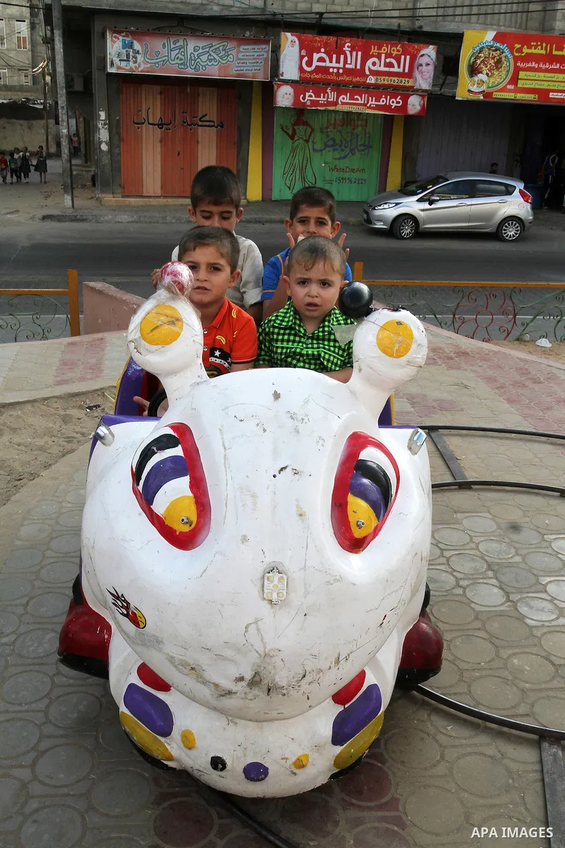 Palestinian children enjoy a ride at an amusement park during the second day of Eid al-Adha or the feast of sacrifice, in Rafah in the southern of Gaza strip, on Sep. 13, 2016. Muslims across the world are celebrating th...