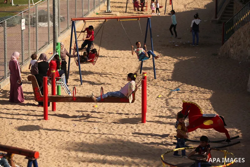 Palestinian children play at an amusement park on the third day of Eid al-Adha or the feast of sacrifice in Gaza city, on Sep. 14, 2016. Muslims across the world are celebrating the annual festival of Eid al-Adha, or the...