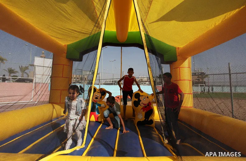Palestinian children play at an amusement park on the third day of Eid al-Adha or the feast of sacrifice in Gaza city, on Sep. 14, 2016. Muslims across the world are celebrating the annual festival of Eid al-Adha, or the...