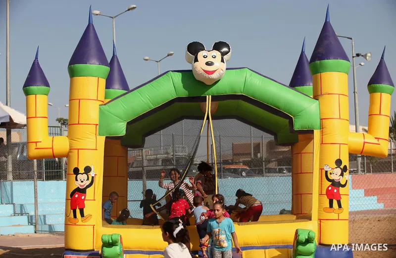 Palestinian children play at an amusement park on the third day of Eid al-Adha or the feast of sacrifice in Gaza city, on Sep. 14, 2016. Muslims across the world are celebrating the annual festival of Eid al-Adha, or the...
