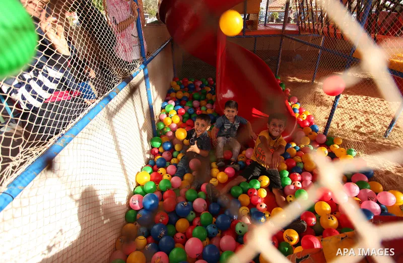 Palestinian children play at an amusement park on the third day of Eid al-Adha or the feast of sacrifice in Gaza city, on Sep. 14, 2016. Muslims across the world are celebrating the annual festival of Eid al-Adha, or the...