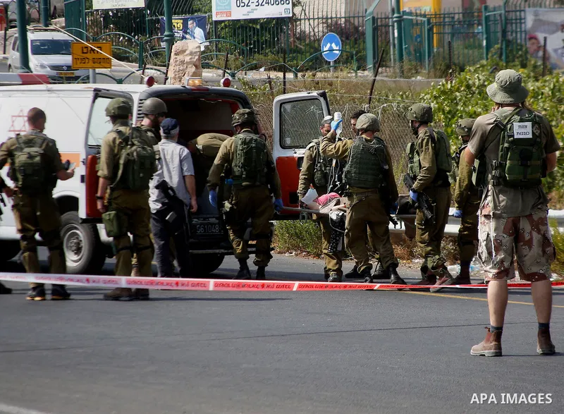 Israeli soldiers carry wounded Palestinian Raghad Khadour at the scene of what the Israeli military said was a car ramming attack by a Palestinian near the Jewish settlement of Kiryat Arba near the West Bank city of Hebr...