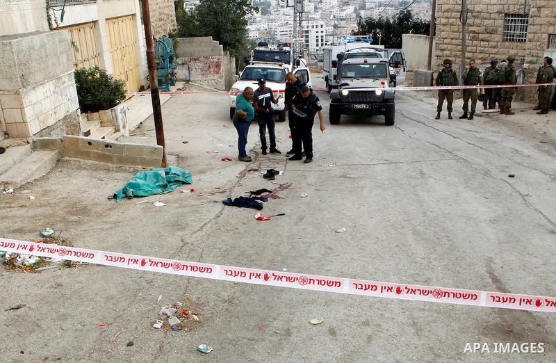 Israeli security forces gather at the scene of a stabbing attack, where a Palestinian stabbed an Israeli soldier before he was shot dead, in the flashpoint West Bank city of Hebron on September 17, 2016. An Israeli milit...