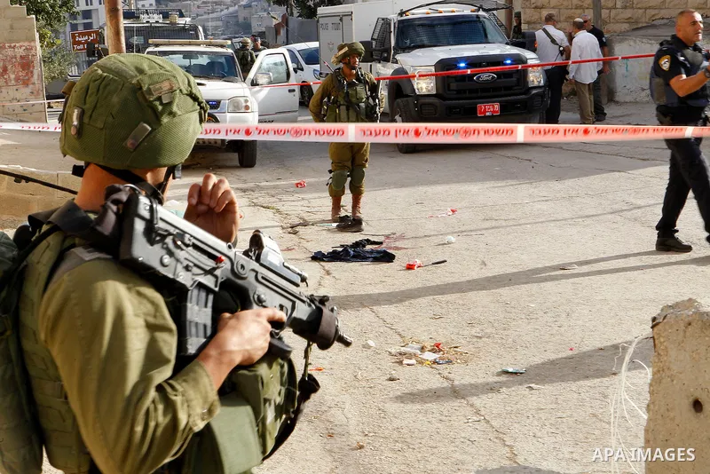 Israeli security forces gather at the scene of a stabbing attack, where a Palestinian stabbed an Israeli soldier before he was shot dead, in the flashpoint West Bank city of Hebron on September 17, 2016. An Israeli milit...
