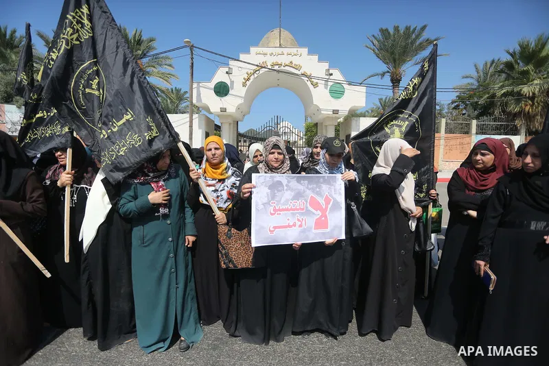 Palestinian supporters of the Islamic Jihad Movement hold banners against the security coordination in front of the Legislative Council, in Gaza city, on September 17, 2016. Photo by Mohammed Asad