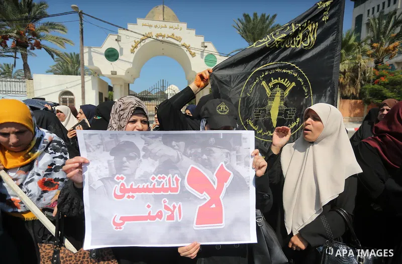 Palestinian supporters of the Islamic Jihad Movement hold banners against the security coordination in front of the Legislative Council, in Gaza city, on September 17, 2016. Photo by Mohammed Asad