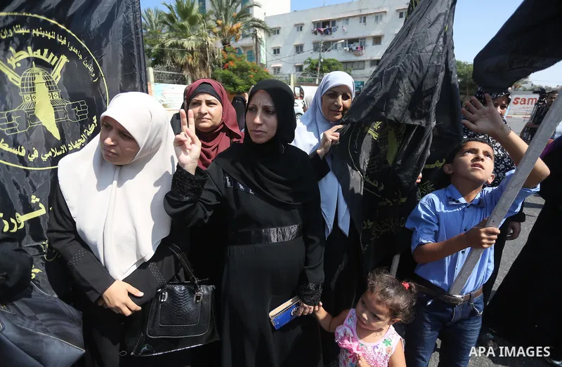 Palestinian supporters of the Islamic Jihad Movement hold banners against the security coordination in front of the Legislative Council, in Gaza city, on September 17, 2016. Photo by Mohammed Asad