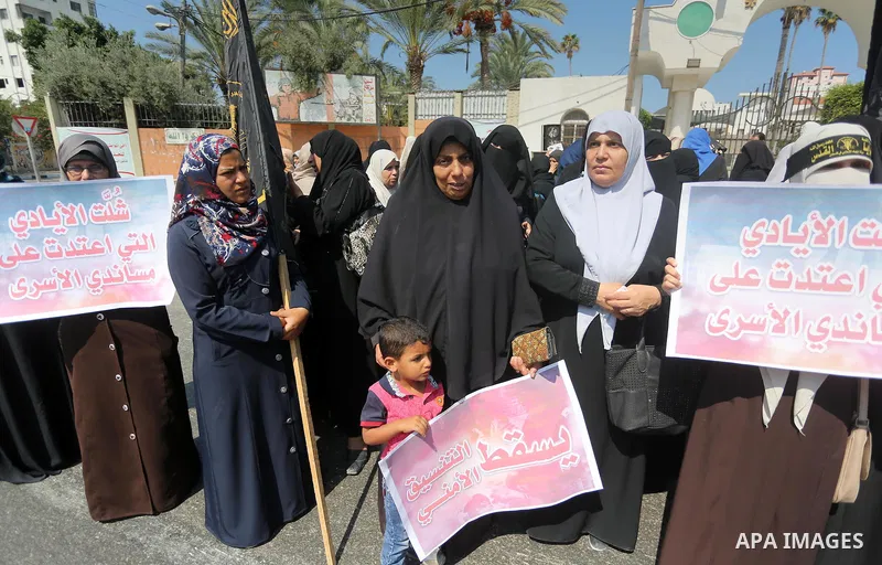 Palestinian supporters of the Islamic Jihad Movement hold banners against the security coordination in front of the Legislative Council, in Gaza city, on September 17, 2016. Photo by Mohammed Asad