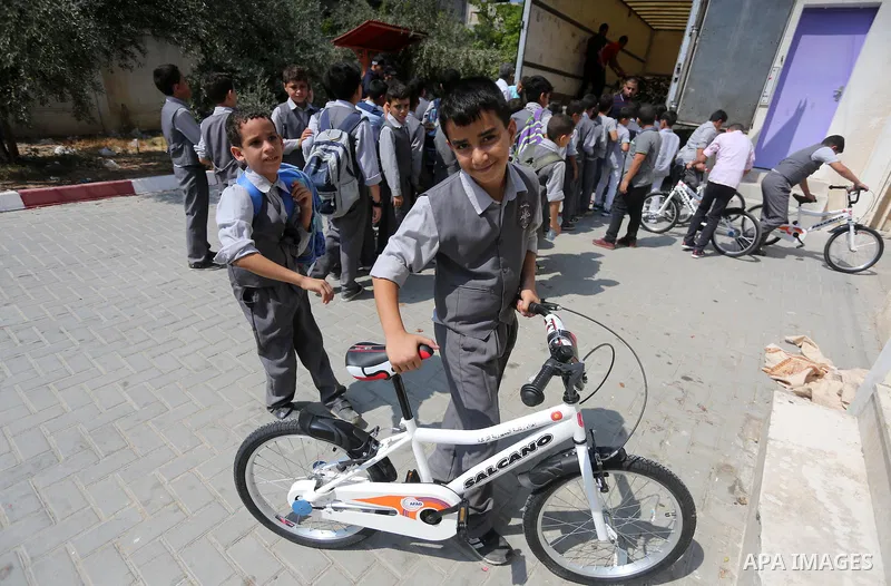 Palestinian orphan student receive bicycles from Turkish aid "clips", in Gaza City, on Sept. 17, 2016. Photo by Mohammed Asad