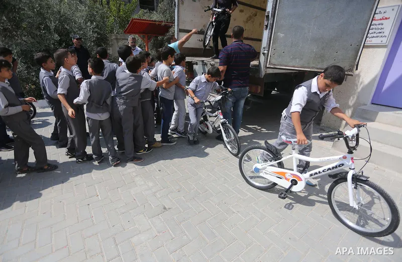 Palestinian orphan student receive bicycles from Turkish aid "clips", in Gaza City, on Sept. 17, 2016. Photo by Mohammed Asad