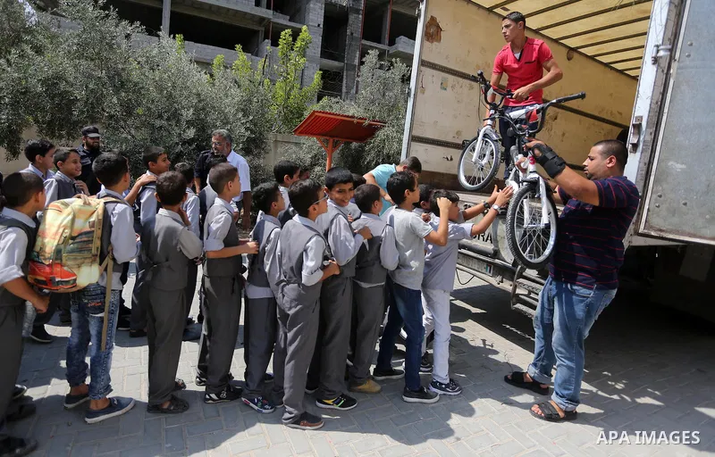 Palestinian orphan student receive bicycles from Turkish aid "clips", in Gaza City, on Sept. 17, 2016. Photo by Mohammed Asad