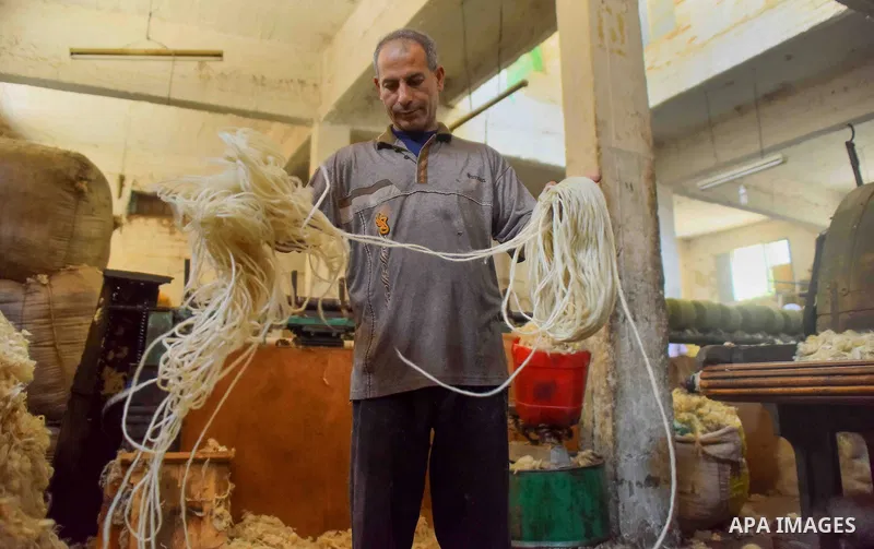 A worker prepares wool for production in a factory in Beheira Governorate, Egypt on September 3, 2016. Photo by Amr Sayed