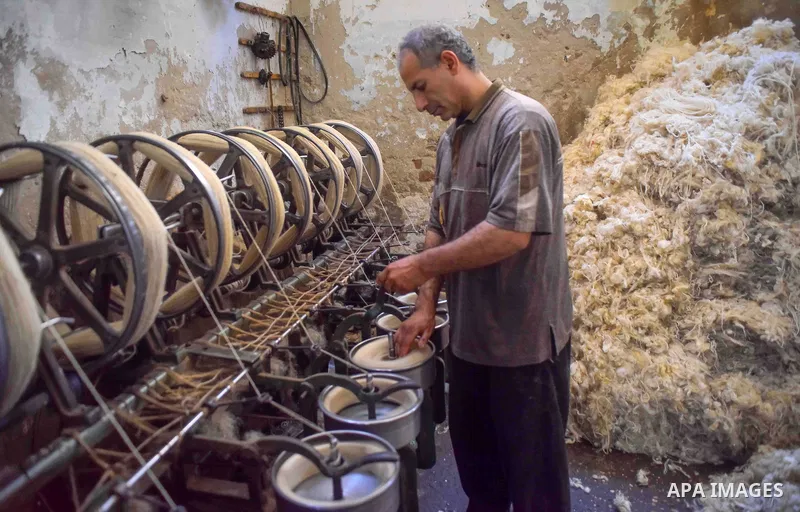 A worker prepares wool for production in a factory in Beheira Governorate, Egypt on September 3, 2016. Photo by Amr Sayed