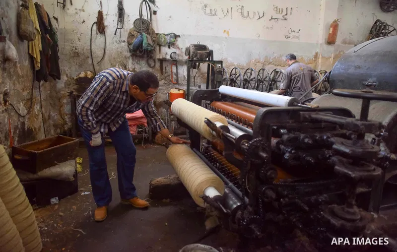A worker prepares wool for production in a factory in Beheira Governorate, Egypt on September 3, 2016. Photo by Amr Sayed