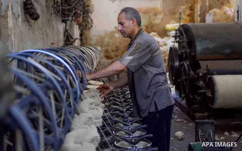 A worker prepares wool for production in a factory in Beheira Governorate, Egypt on September 3, 2016. Photo by Amr Sayed