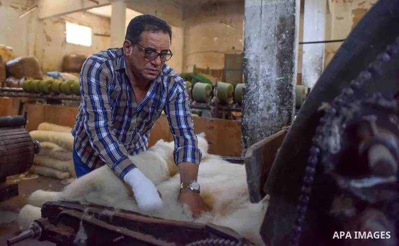 A worker prepares wool for production in a factory in Beheira Governorate, Egypt on September 3, 2016. Photo by Amr Sayed