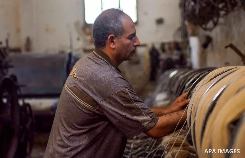 A worker prepares wool for production in a factory in Beheira Governorate, Egypt on September 3, 2016. Photo by Amr Sayed