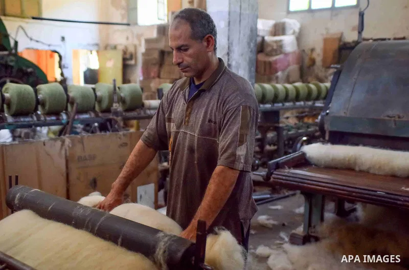 A worker prepares wool for production in a factory in Beheira Governorate, Egypt on September 3, 2016. Photo by Amr Sayed