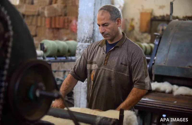 A worker prepares wool for production in a factory in Beheira Governorate, Egypt on September 3, 2016. Photo by Amr Sayed