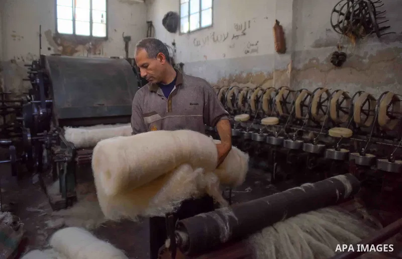 A worker prepares wool for production in a factory in Beheira Governorate, Egypt on September 3, 2016. Photo by Amr Sayed